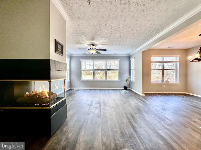 unfurnished living room with crown molding, dark hardwood / wood-style floors, ceiling fan with notable chandelier, and a textured ceiling