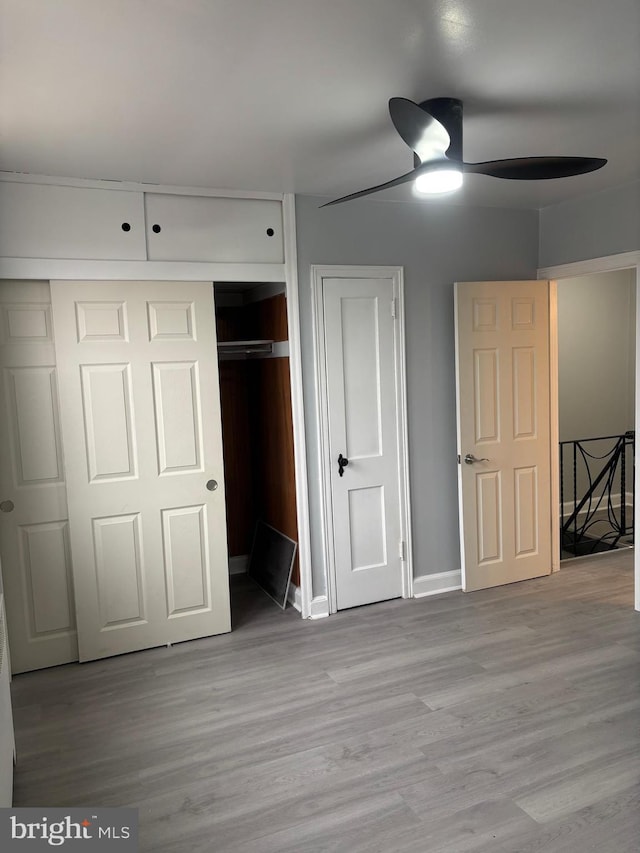 unfurnished bedroom with ceiling fan, a closet, and light hardwood / wood-style floors