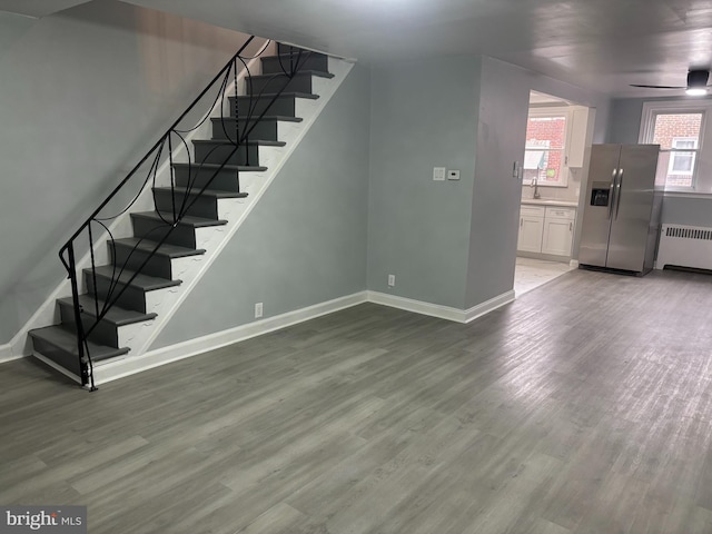 interior space featuring sink, hardwood / wood-style flooring, and radiator heating unit