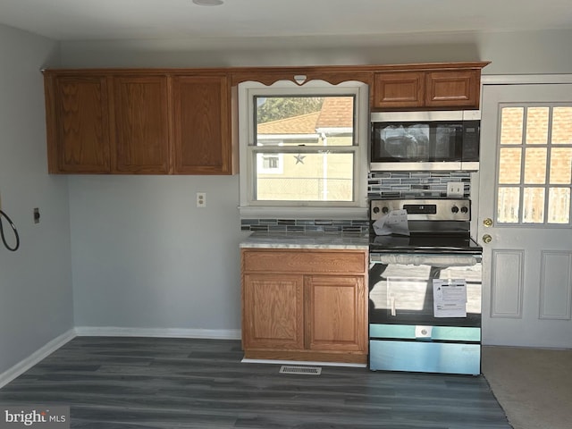 kitchen with stainless steel appliances, decorative backsplash, and dark hardwood / wood-style flooring