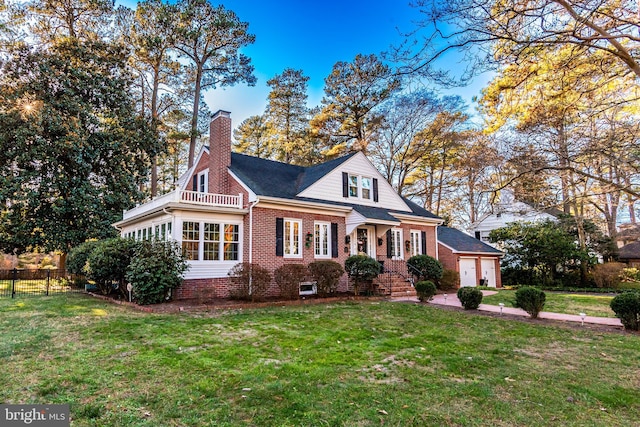 cape cod house with a balcony and a front yard