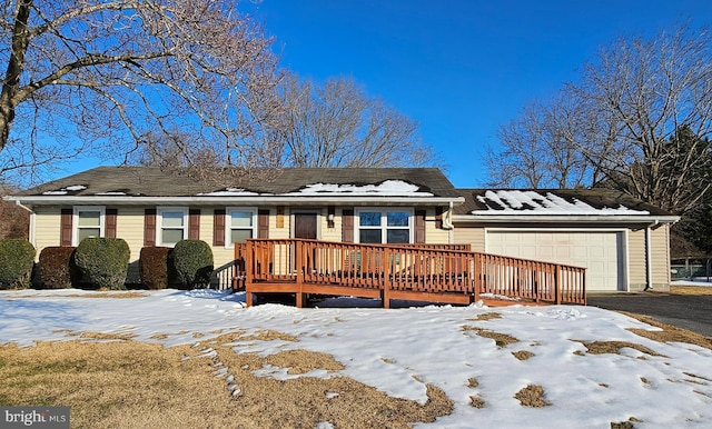 single story home featuring a deck and a garage