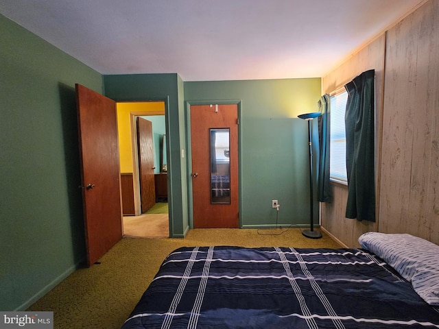 carpeted bedroom with wood walls