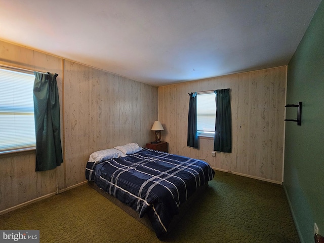 bedroom with dark carpet and wooden walls