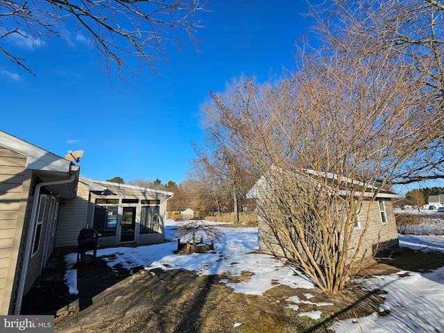 yard layered in snow with a sunroom