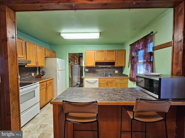 kitchen with kitchen peninsula, a kitchen breakfast bar, white appliances, and gas water heater