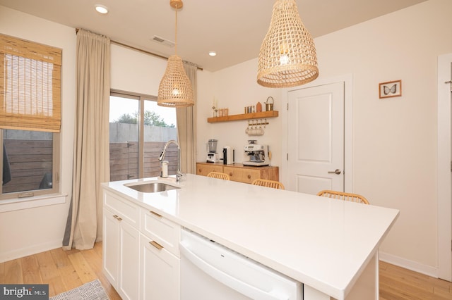 kitchen with an island with sink, dishwasher, sink, and pendant lighting