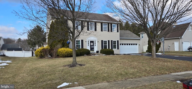 colonial house featuring a garage and a front yard