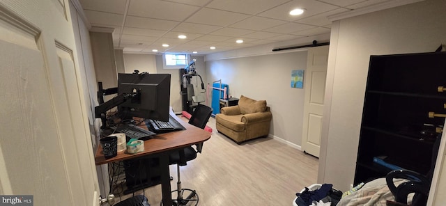 office area with light wood-type flooring and a barn door