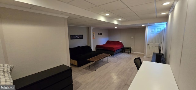 bedroom with a drop ceiling and light hardwood / wood-style flooring