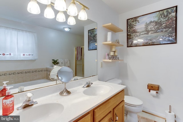 bathroom featuring toilet, a bath, and vanity