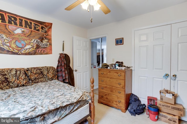 bedroom with ceiling fan, light colored carpet, and a closet