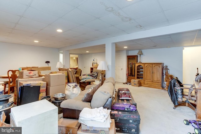 basement featuring light carpet and a paneled ceiling