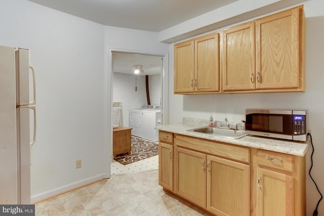 kitchen featuring sink, white refrigerator, and light brown cabinetry