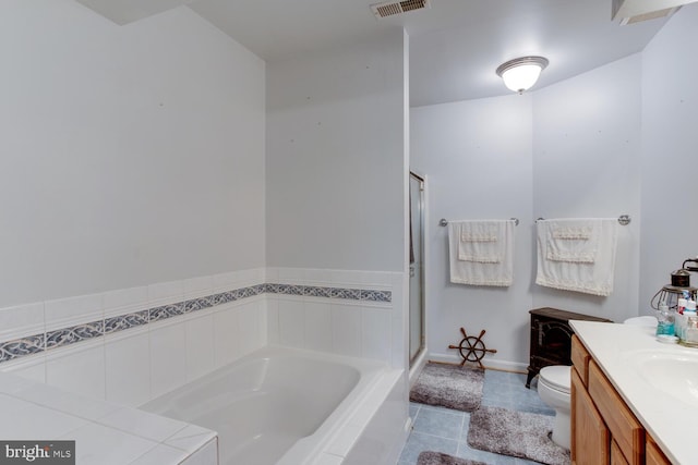 bathroom featuring tiled tub, toilet, and vanity