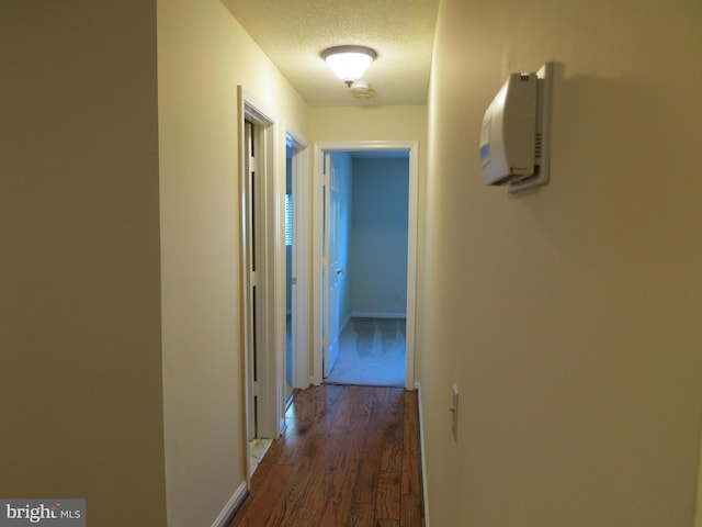 hall with dark wood-style floors and a textured ceiling