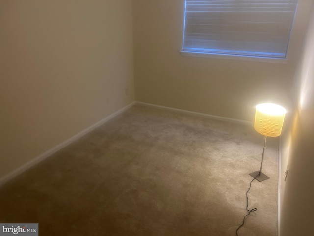 unfurnished room with carpet flooring and baseboards