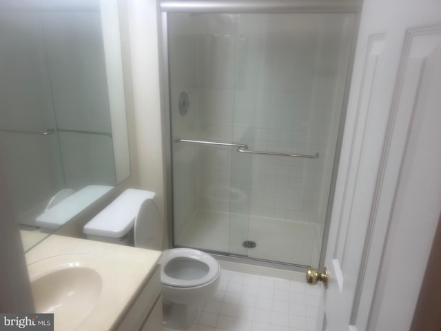 bathroom with vanity, a shower stall, and toilet