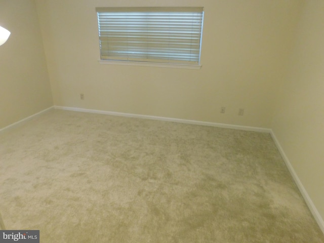 empty room featuring baseboards and carpet floors