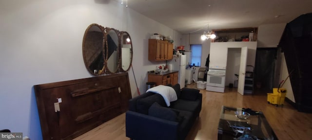 living room featuring light wood-type flooring and a chandelier