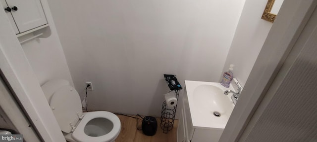 bathroom with toilet, hardwood / wood-style floors, and vanity