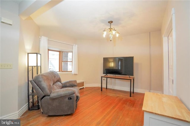 living room with hardwood / wood-style floors and an inviting chandelier