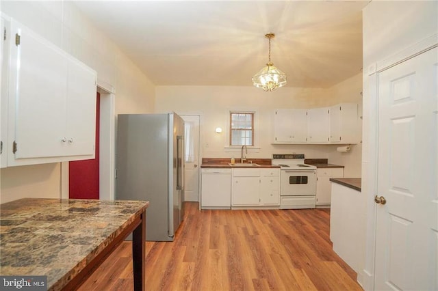 kitchen with white appliances, white cabinets, sink, hanging light fixtures, and light hardwood / wood-style flooring