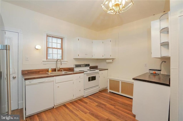 kitchen featuring white cabinets, radiator, sink, and white appliances