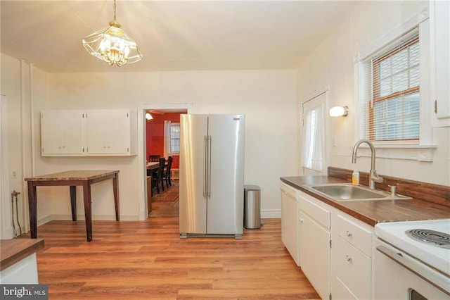 kitchen with white cabinets, decorative light fixtures, sink, a chandelier, and high end fridge