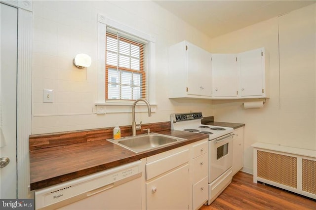 kitchen featuring white cabinetry, radiator heating unit, white appliances, dark wood-type flooring, and sink