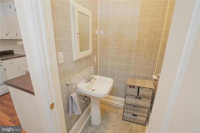 bathroom featuring tile patterned flooring and tile walls