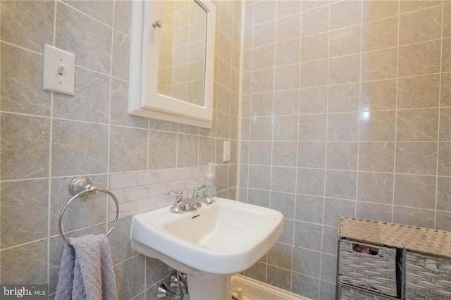 bathroom with sink, tile walls, and tasteful backsplash