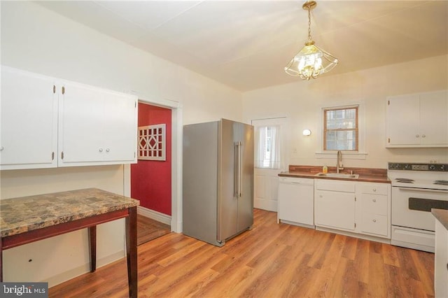 kitchen with white cabinets, sink, white appliances, and pendant lighting