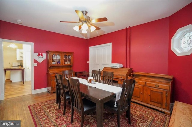 dining space featuring light wood-type flooring and ceiling fan