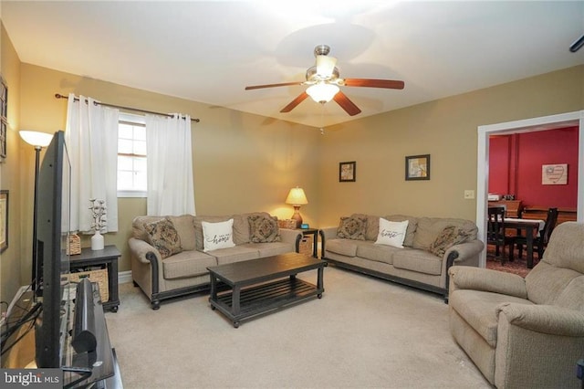 carpeted living room with ceiling fan