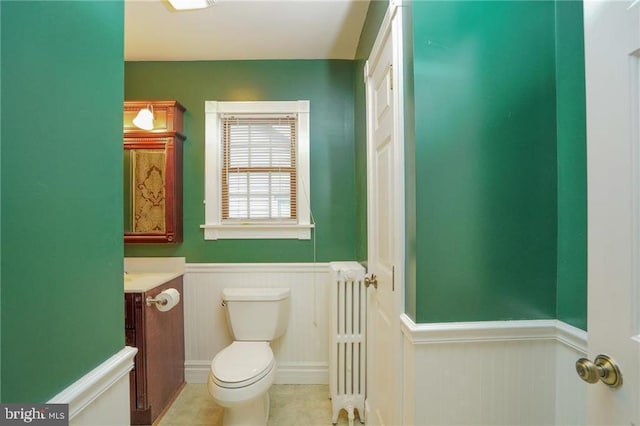 bathroom featuring tile patterned flooring, toilet, radiator heating unit, and vanity