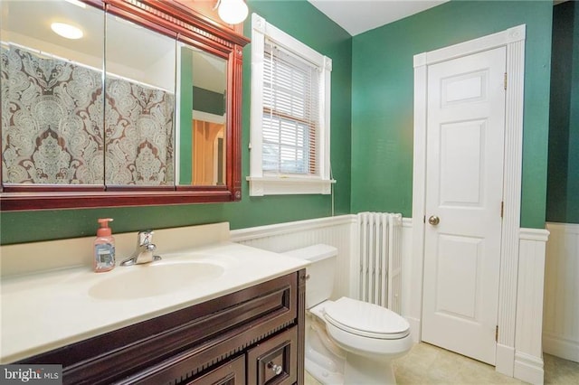 bathroom with toilet, vanity, and radiator heating unit