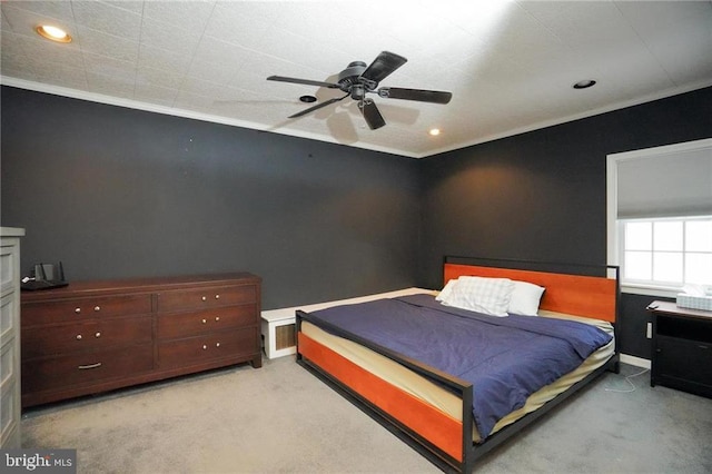 carpeted bedroom featuring ceiling fan and crown molding