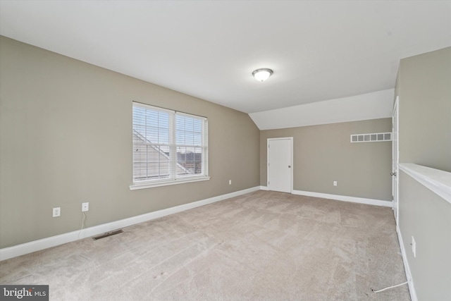 empty room with lofted ceiling and light colored carpet