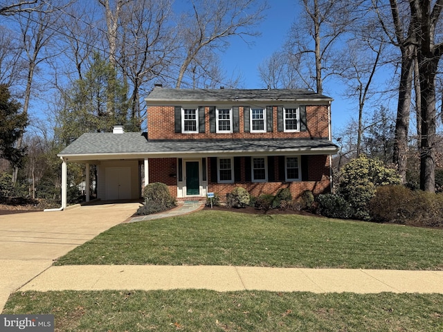 view of front facade featuring a front lawn, a carport, concrete driveway, brick siding, and a chimney