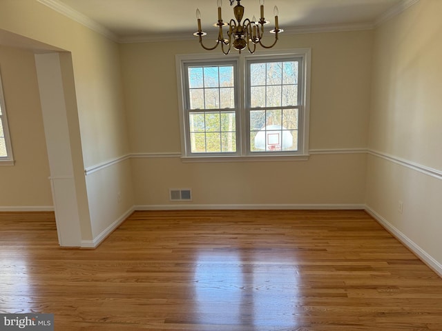 unfurnished dining area featuring crown molding, a notable chandelier, visible vents, and light wood finished floors