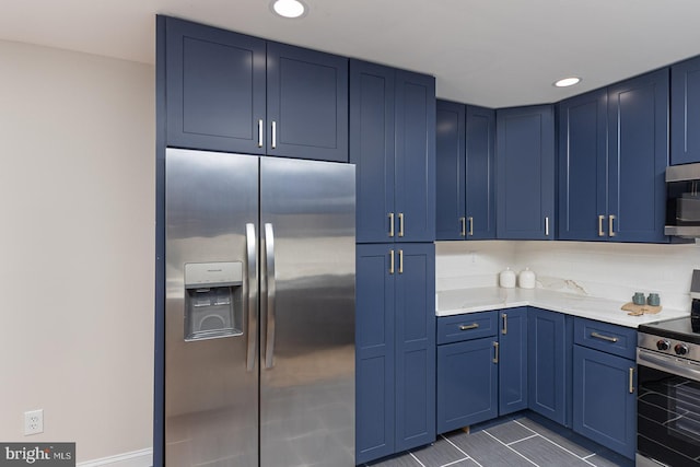 kitchen featuring stainless steel appliances, light stone countertops, and blue cabinetry