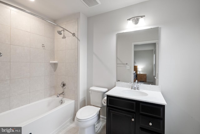 full bathroom featuring tiled shower / bath, vanity, and toilet