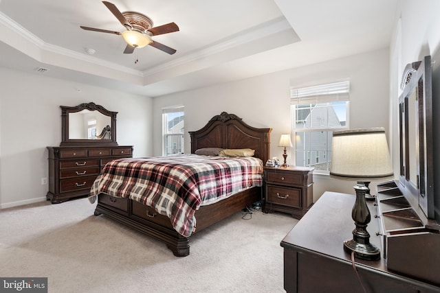 bedroom featuring a tray ceiling, ornamental molding, light colored carpet, and ceiling fan