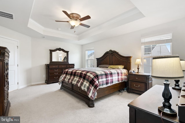 carpeted bedroom featuring crown molding, a tray ceiling, and ceiling fan