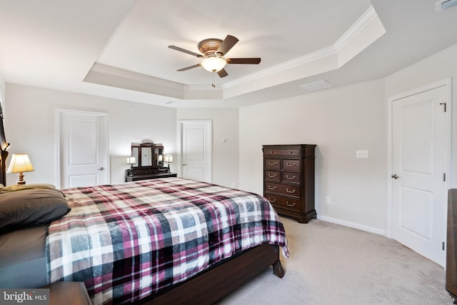 bedroom featuring a tray ceiling, ornamental molding, light colored carpet, and ceiling fan