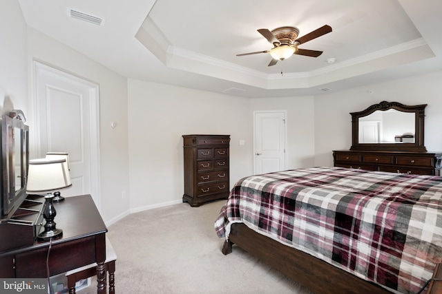 carpeted bedroom featuring ornamental molding, ceiling fan, and a tray ceiling