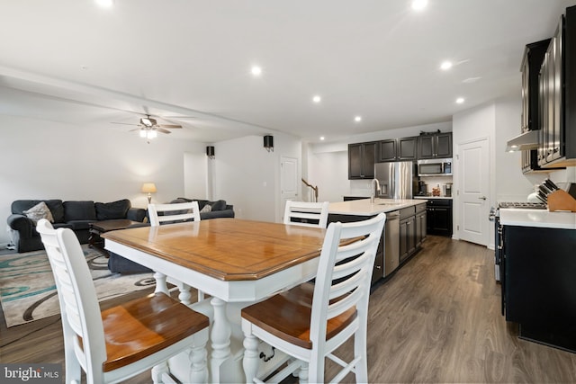 dining area with dark hardwood / wood-style flooring, sink, and ceiling fan