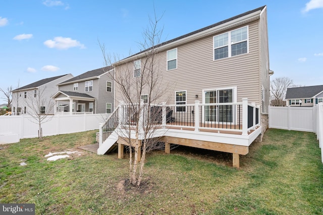 rear view of house with a yard and a deck