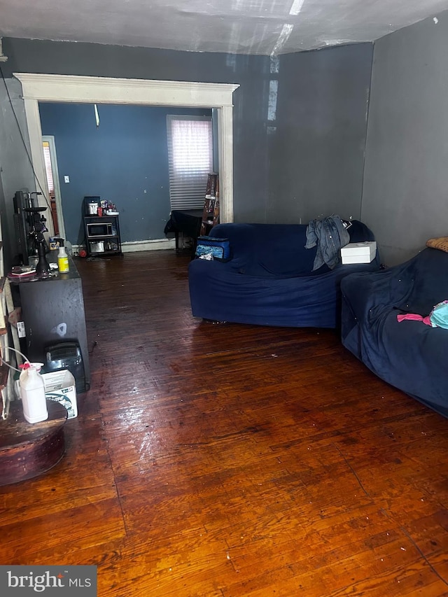 living room with dark wood-type flooring and a baseboard heating unit